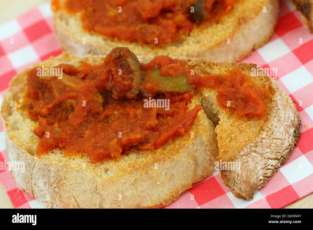 Bruschetta with tomato paste and olives on checkered napkin Stock Photo