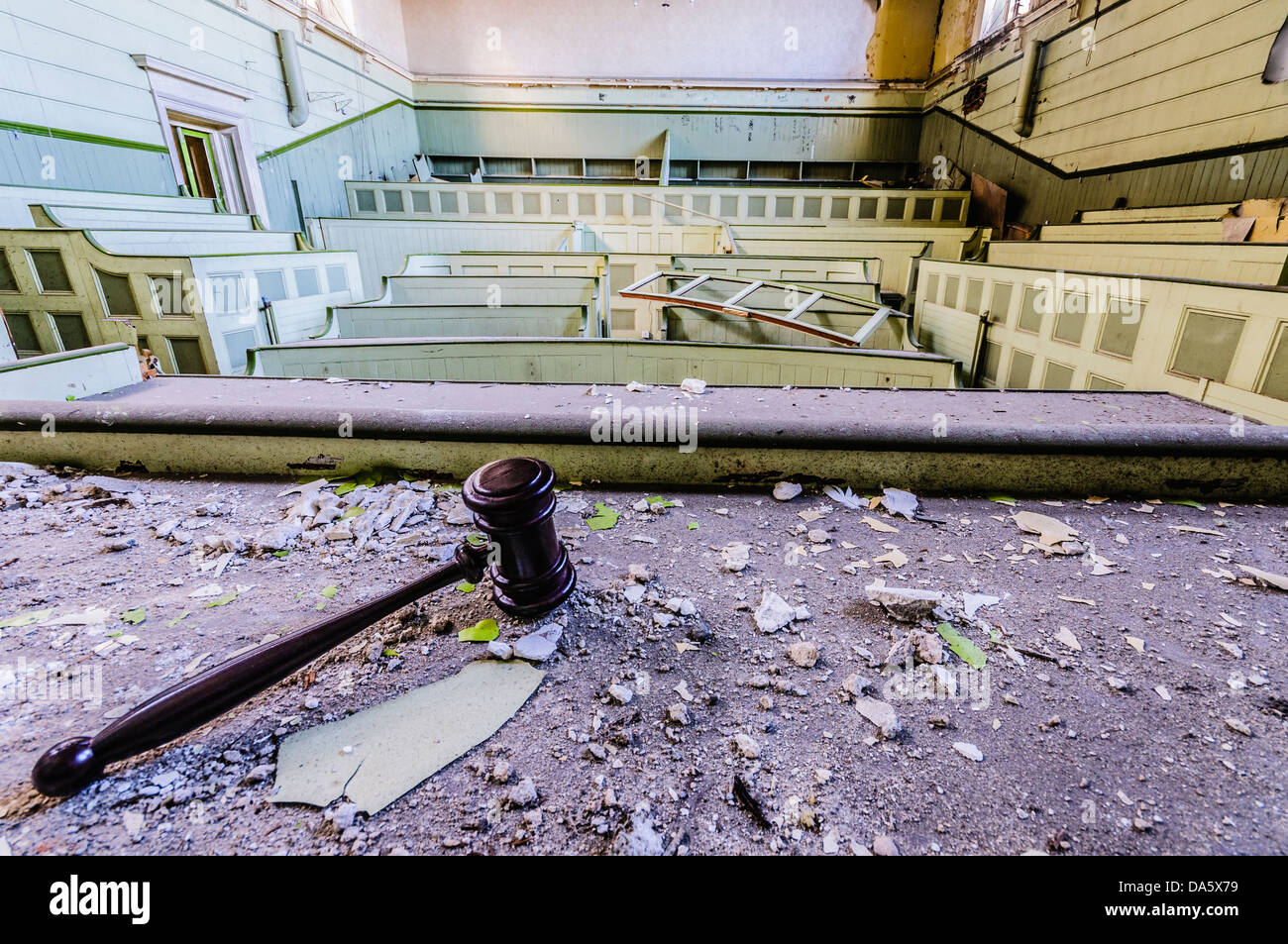 Judge's gavel lying on the bench of a derelict court room Stock Photo