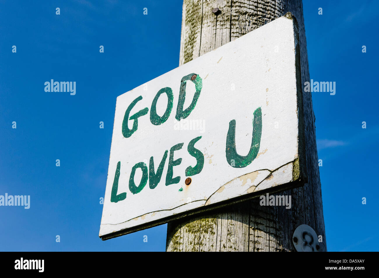 Sign on a lampost with hand-written message 'God Loves U', typical of many signs found in rural parts of Northern Ireland Stock Photo