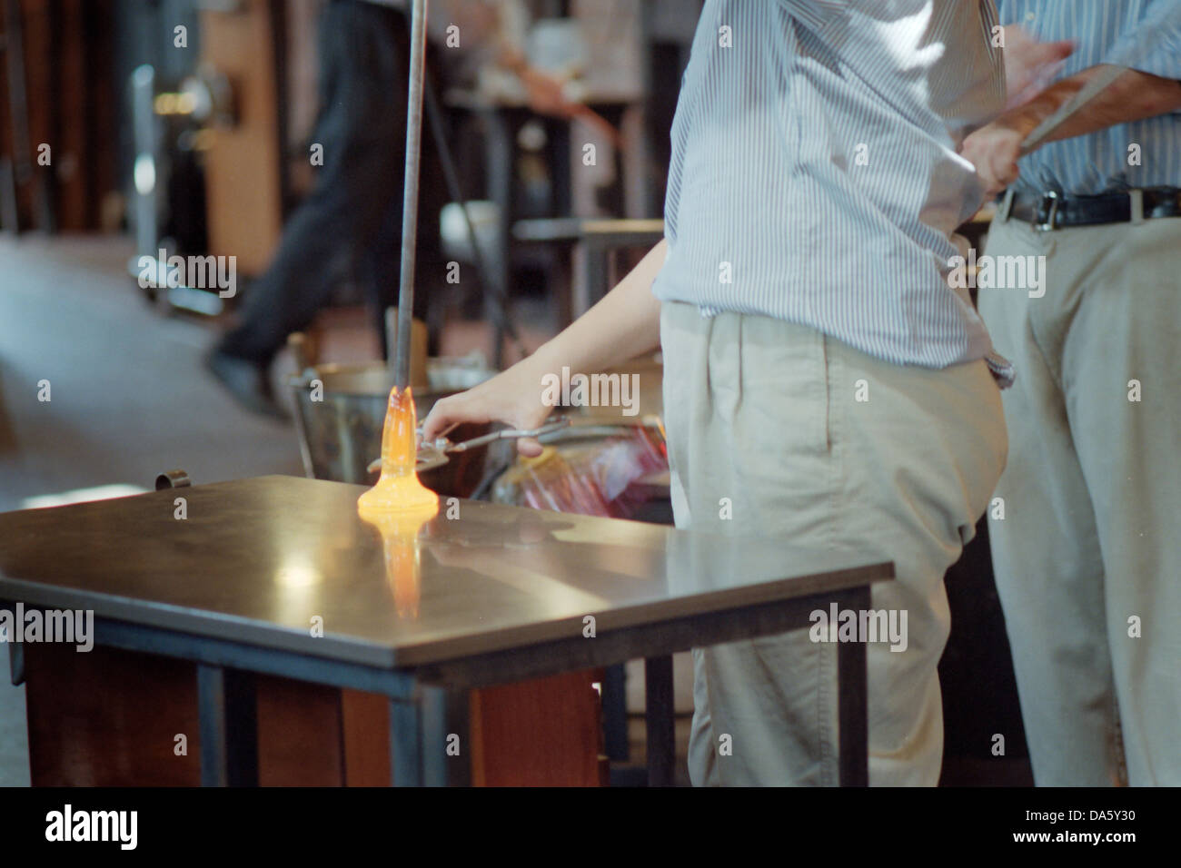 Glass blowers work molten glass to make a vase Stock Photo Alamy