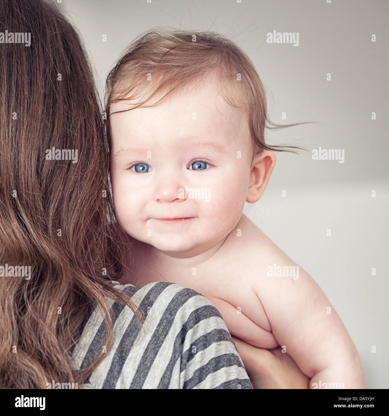 Close-up of mother holding her baby. Look from back. Stock Photo