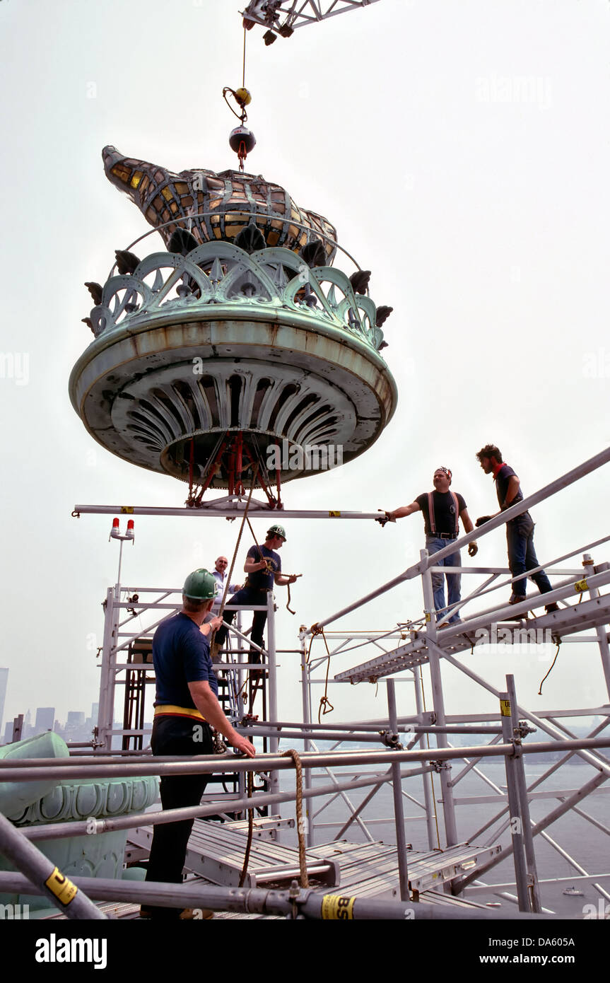 The old torch from the Statue of Liberty is removed from the top of the statue by workers on July 4, 1984 in Liberty Island, New York. The torch will be replaced by a newly designed replica which is more weather resistant. Stock Photo
