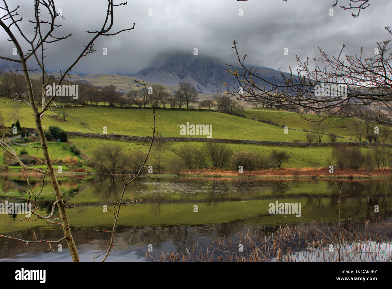 Reflection of a cloud covered Cadair Idris Mountain Range in a still lake Stock Photo