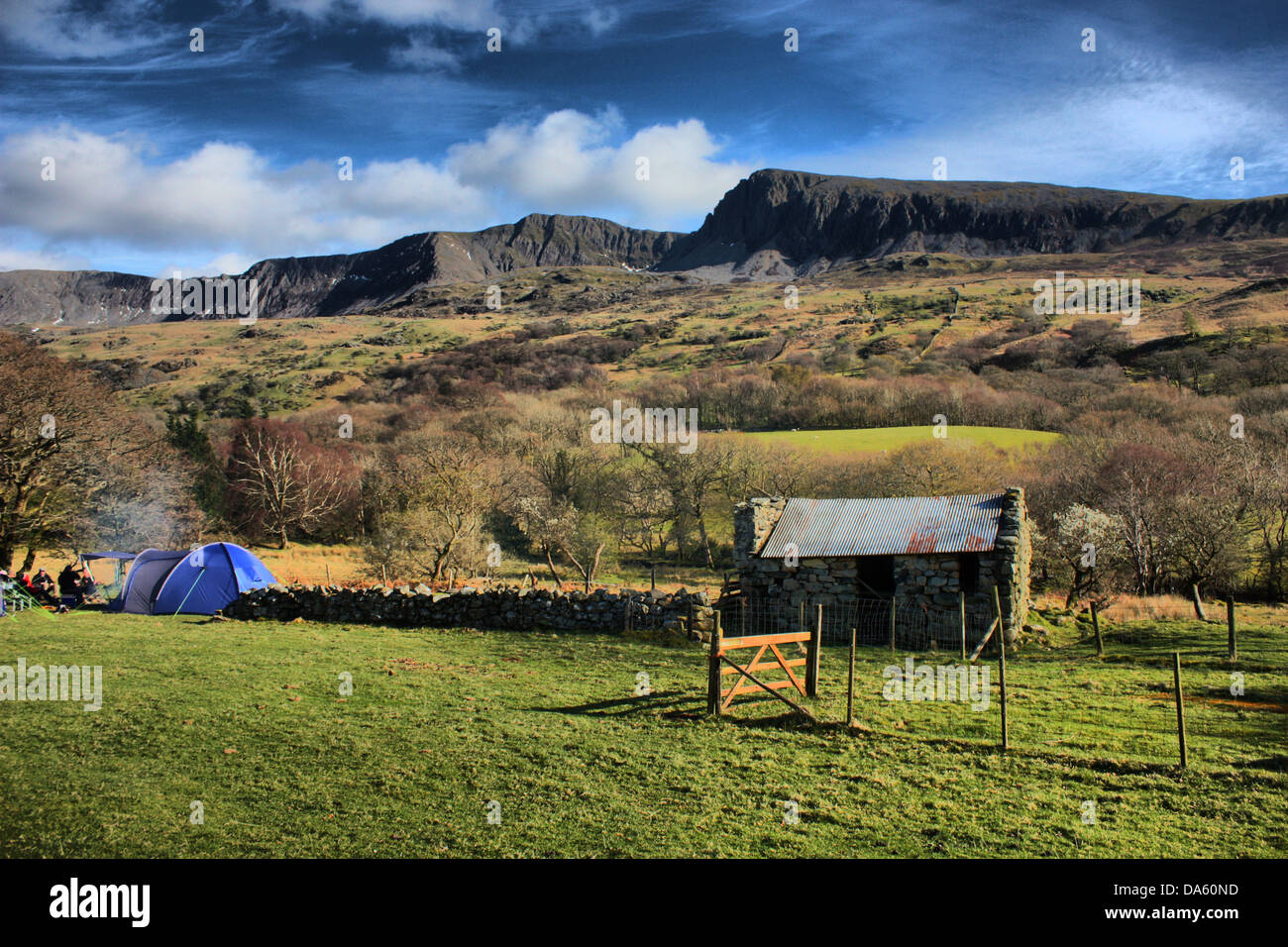 Camping by the Cadair Idris Mountain Range under a blue but cloudy sky Stock Photo