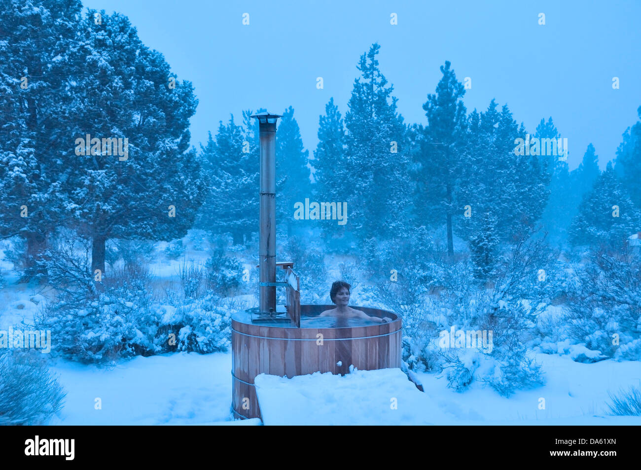 Woman, wood fired, hot tub, snow, winter, snowing, Central Oregon, USA, United States, America, Oregon, relax, wellness Stock Photo