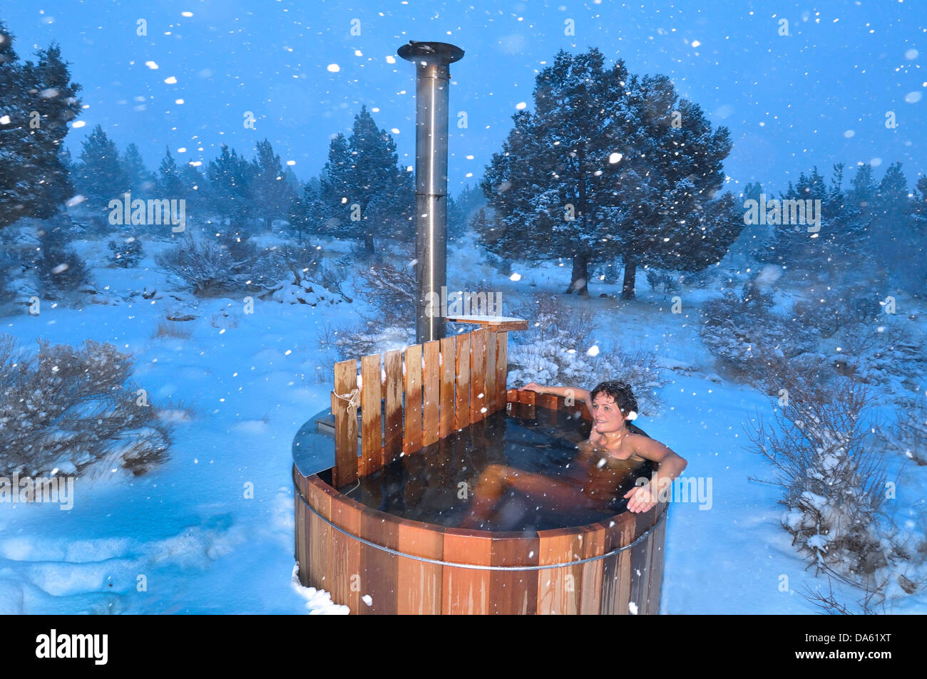Woman, wood fired, hot tub, snow, winter, snowing, Central Oregon, USA, United States, America, Oregon, relax, wellness Stock Photo