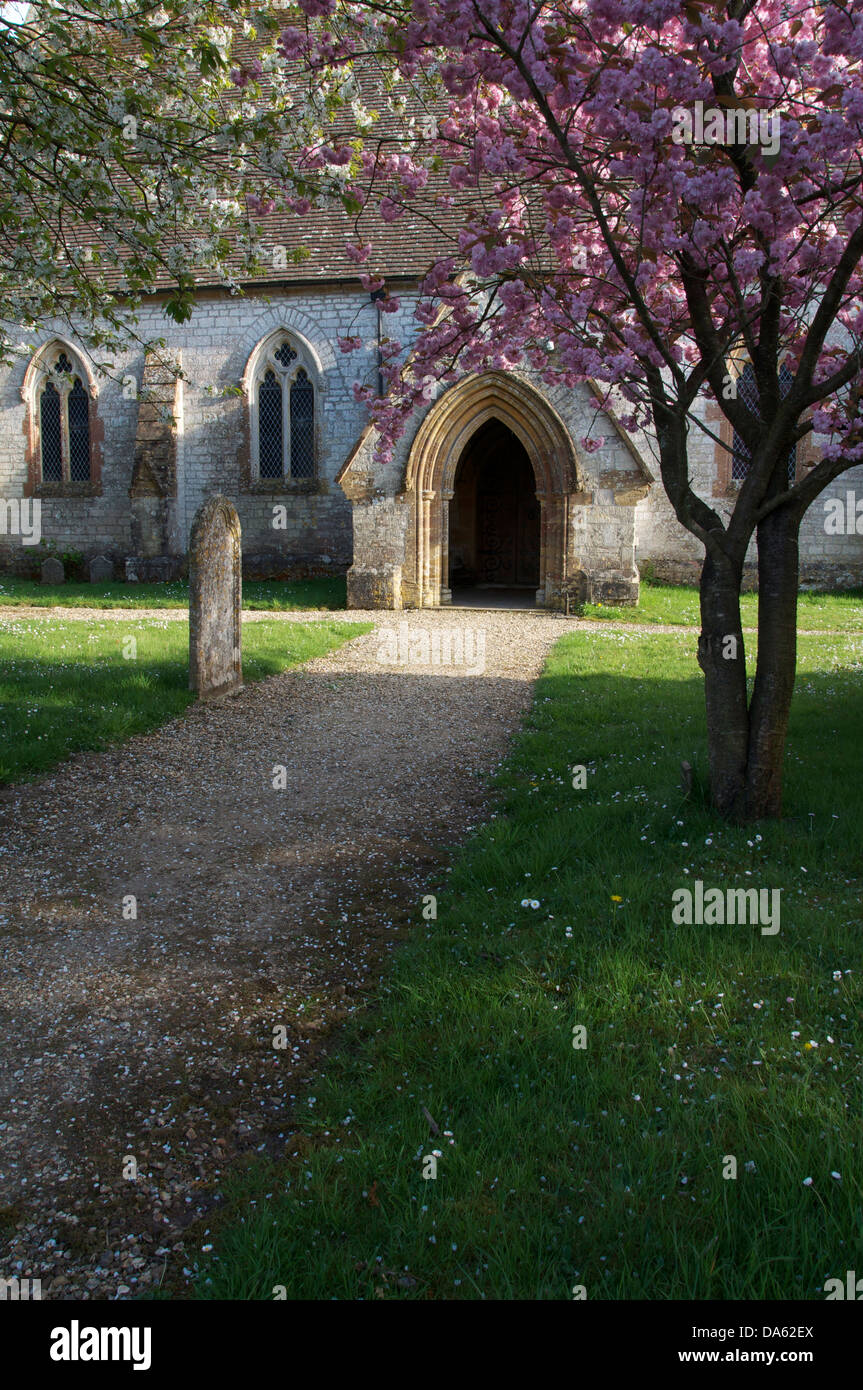 Springtime. The church of Saint John the Evangelist, in the Dorset village of Tincleton. The trees in the churchyard are in blossom. England, UK. Stock Photo