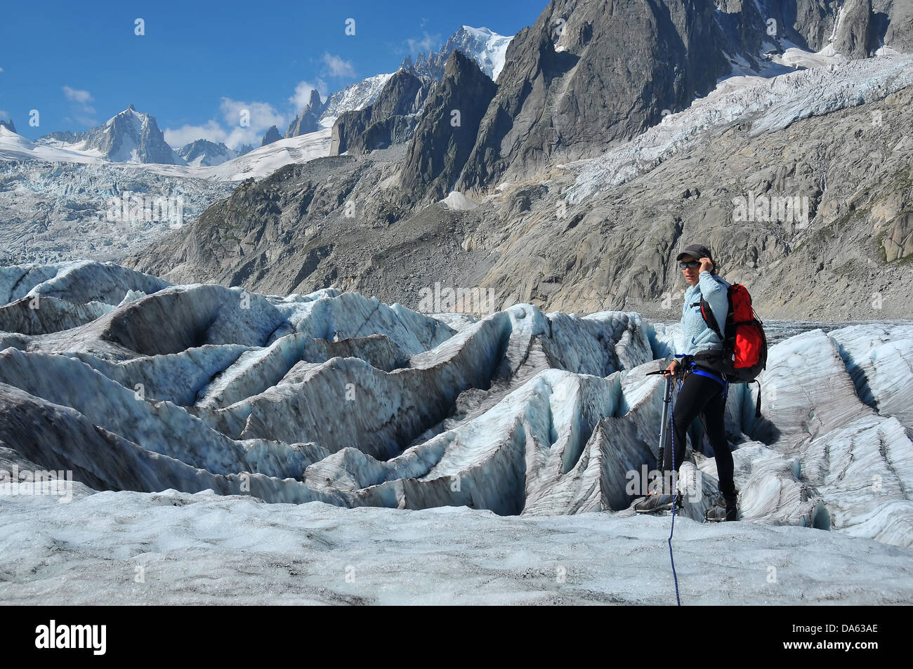 a woman climber crosses an ice fall in the mont blanc massif above ...