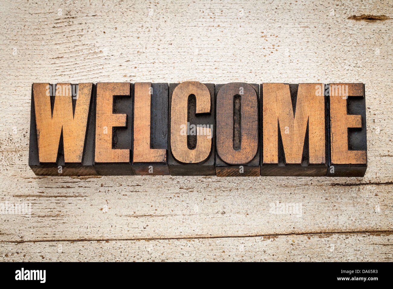 welcome word in vintage letterpress wood type on a grunge painted barn wood background Stock Photo