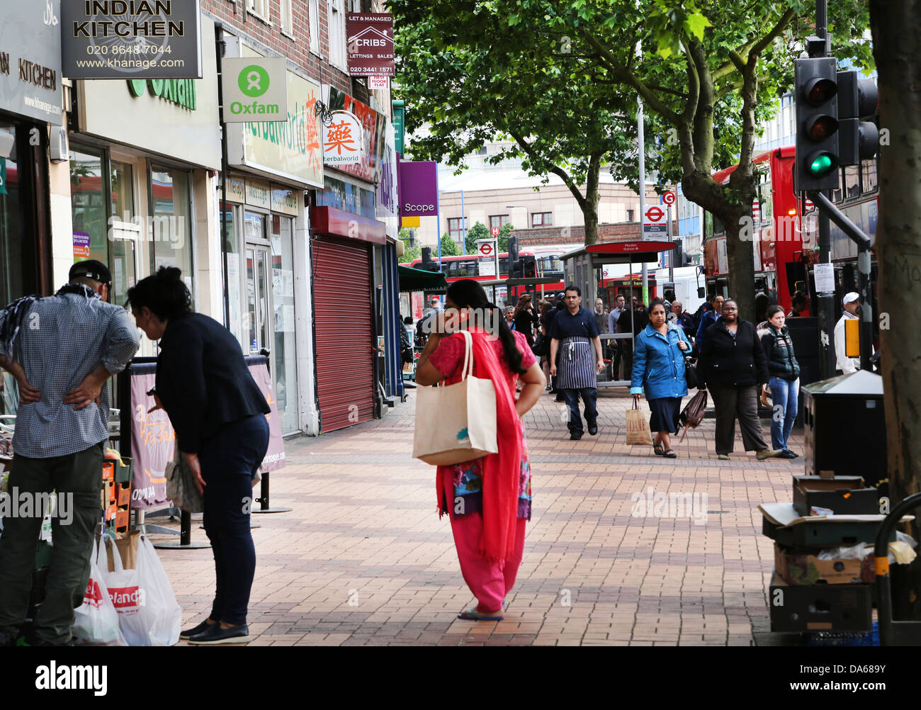 Morden London England People Shopping In High Street Asian Woman on Mobile Phone Stock Photo