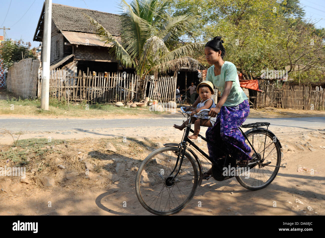 mom and a child on a bicycle in the streets of Bagan Stock Photo
