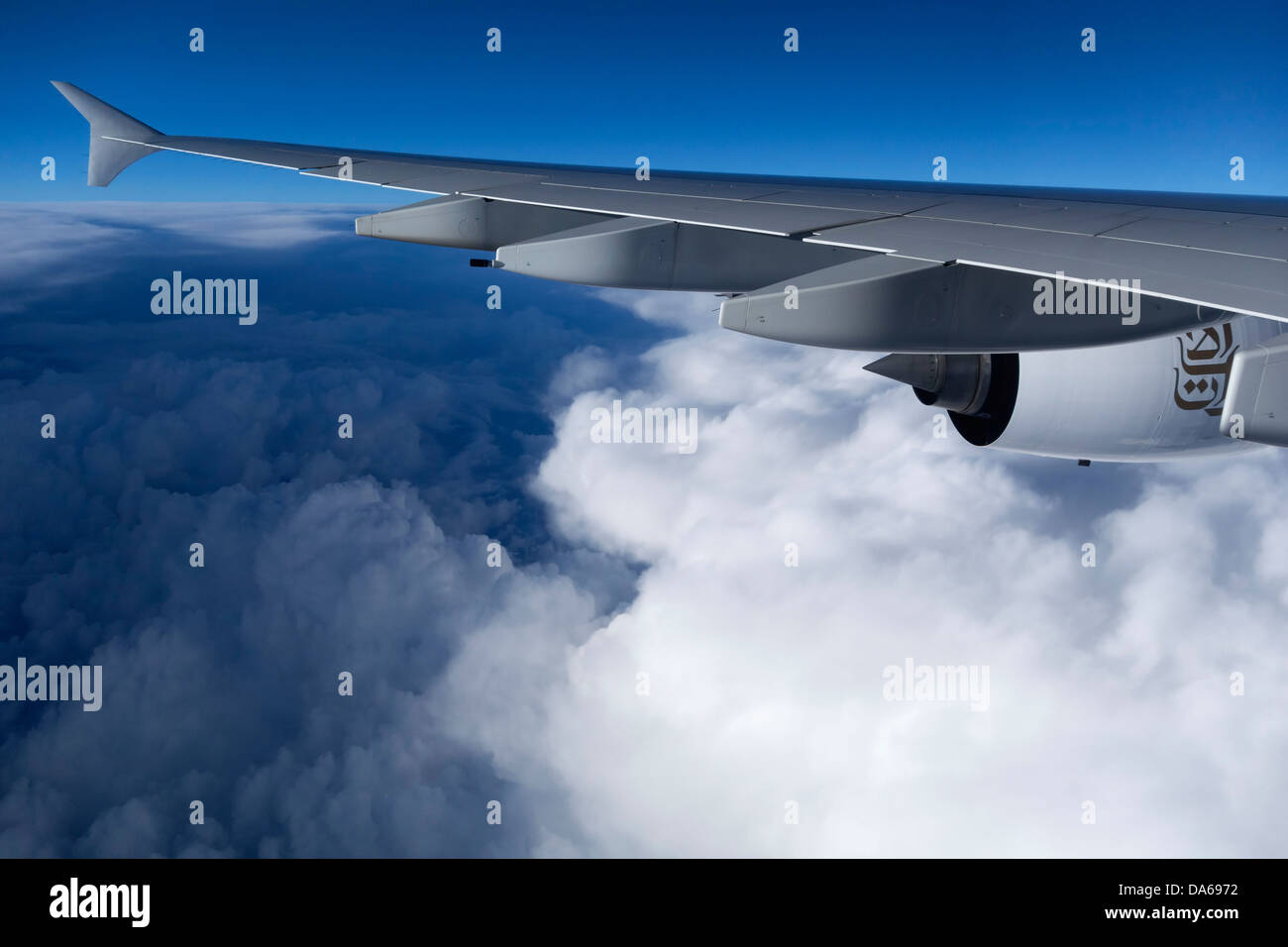 Emirates Airbus A-380 aircraft wing flying above clouds Stock Photo