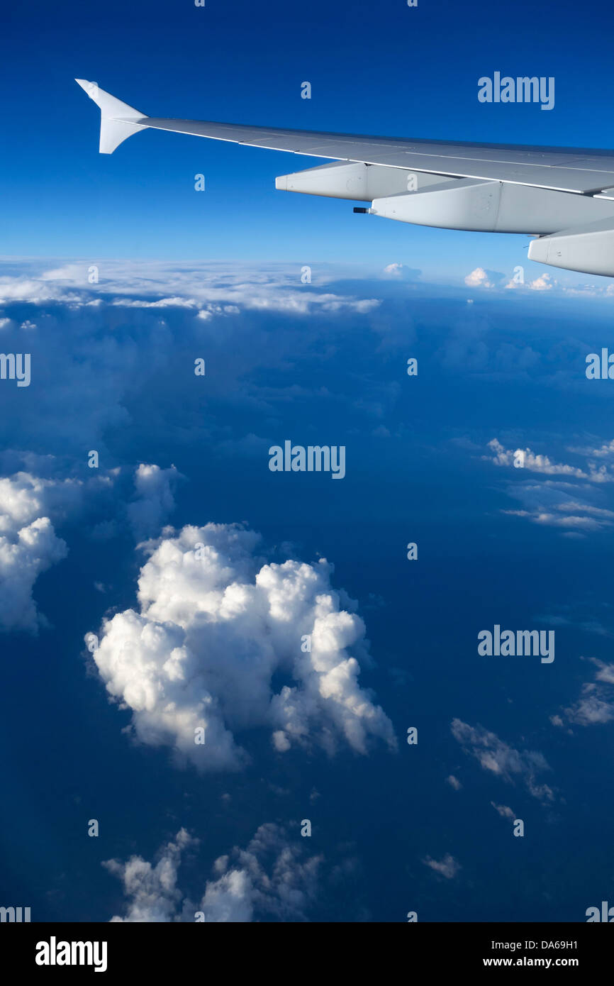 Emirates Airbus A-380 aircraft wing flying above clouds Stock Photo