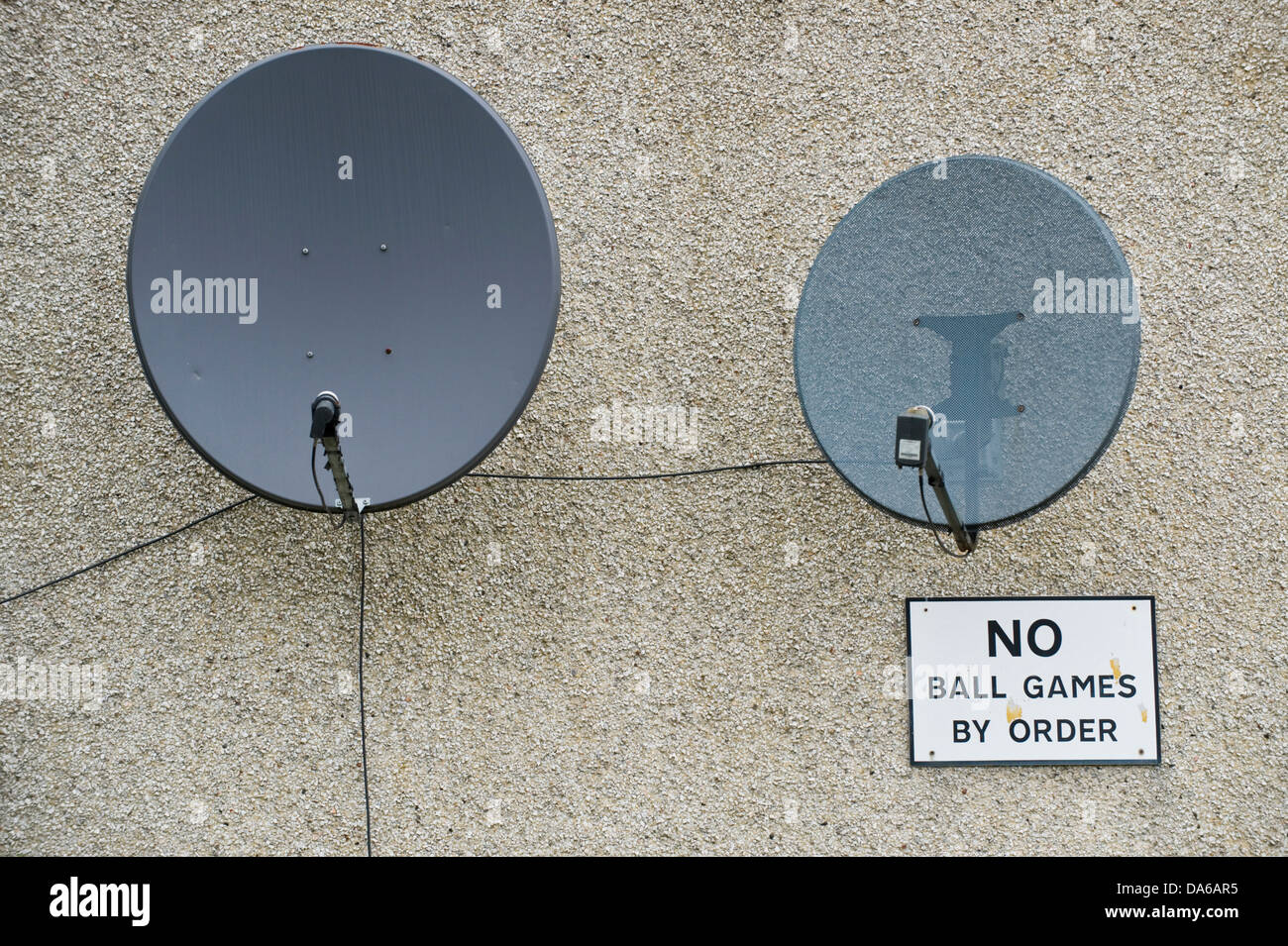 NO BALL GAMES BY ORDER sign & satellite dishes on end wall of house in Leeds West Yorkshire England UK Stock Photo