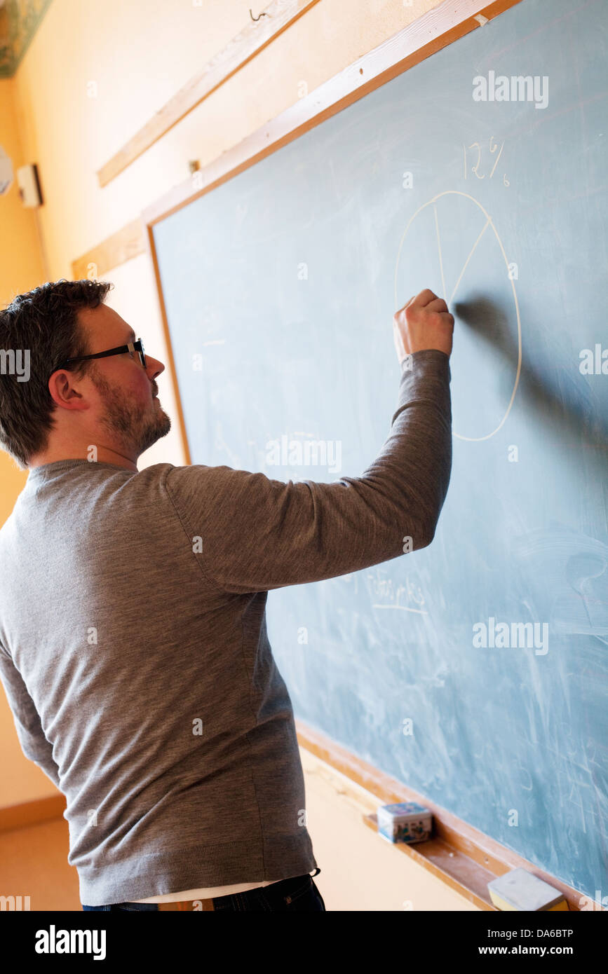 Teacher writing on blackboard Stock Photo Alamy
