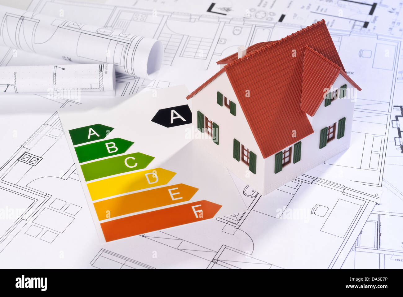 Energy efficiency label with architectural model and blueprints. Stock Photo