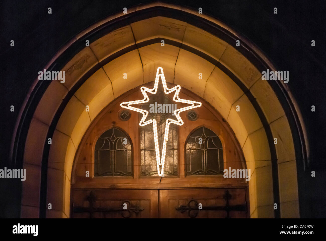 Christmas Star Decoration Illuminating A Church Entrance Stock