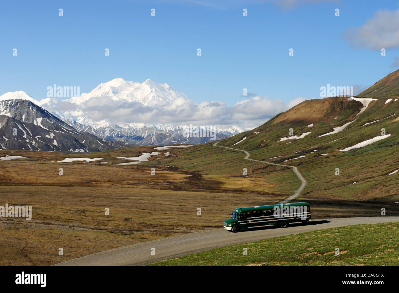 A shuttle bus crossing the Denali National Park and Preserve with views of Mt McKinley at back Stock Photo