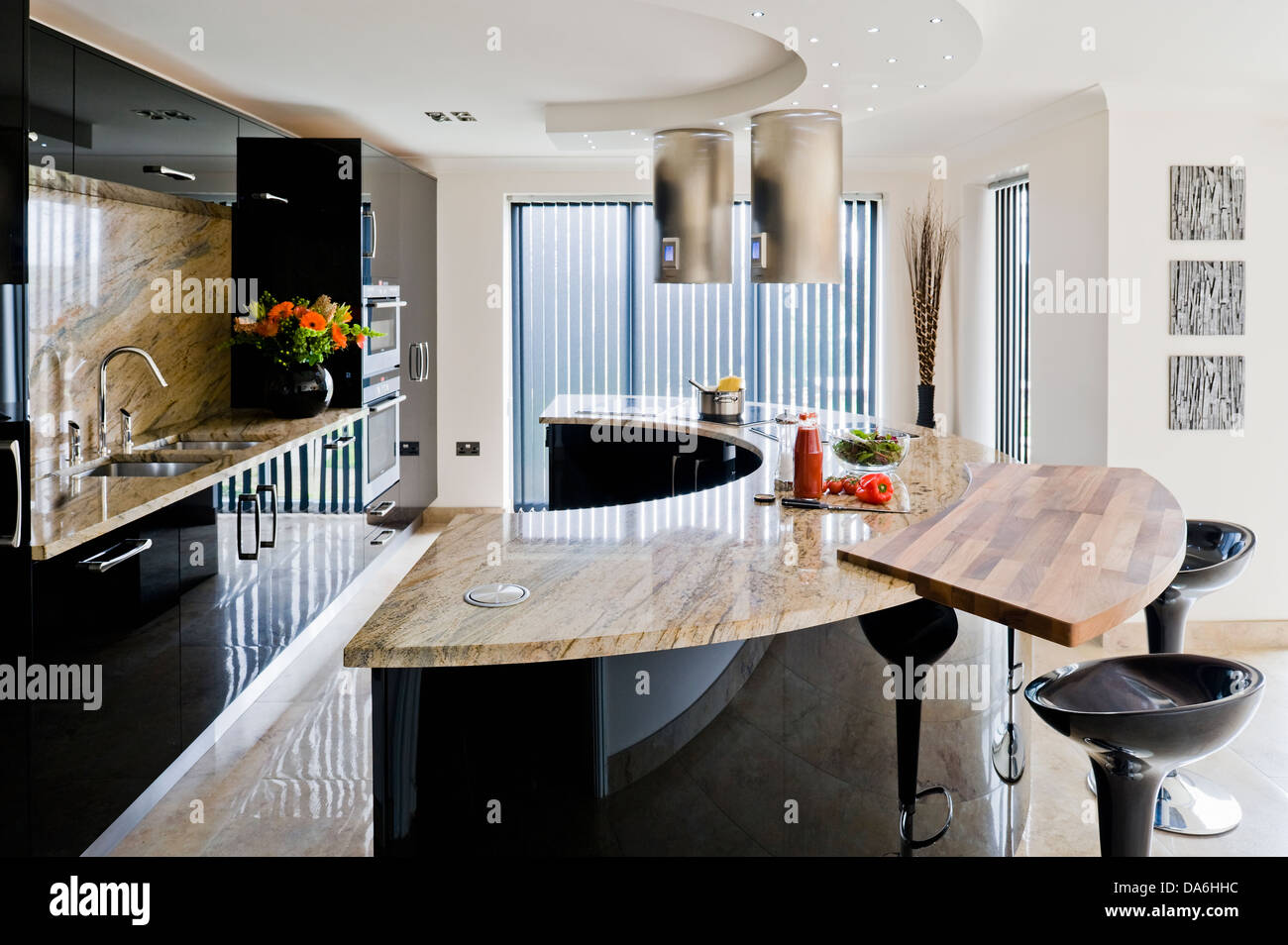 Breakfast bar on curved central unit with marble worktop in large modern kitchen Stock Photo Alamy