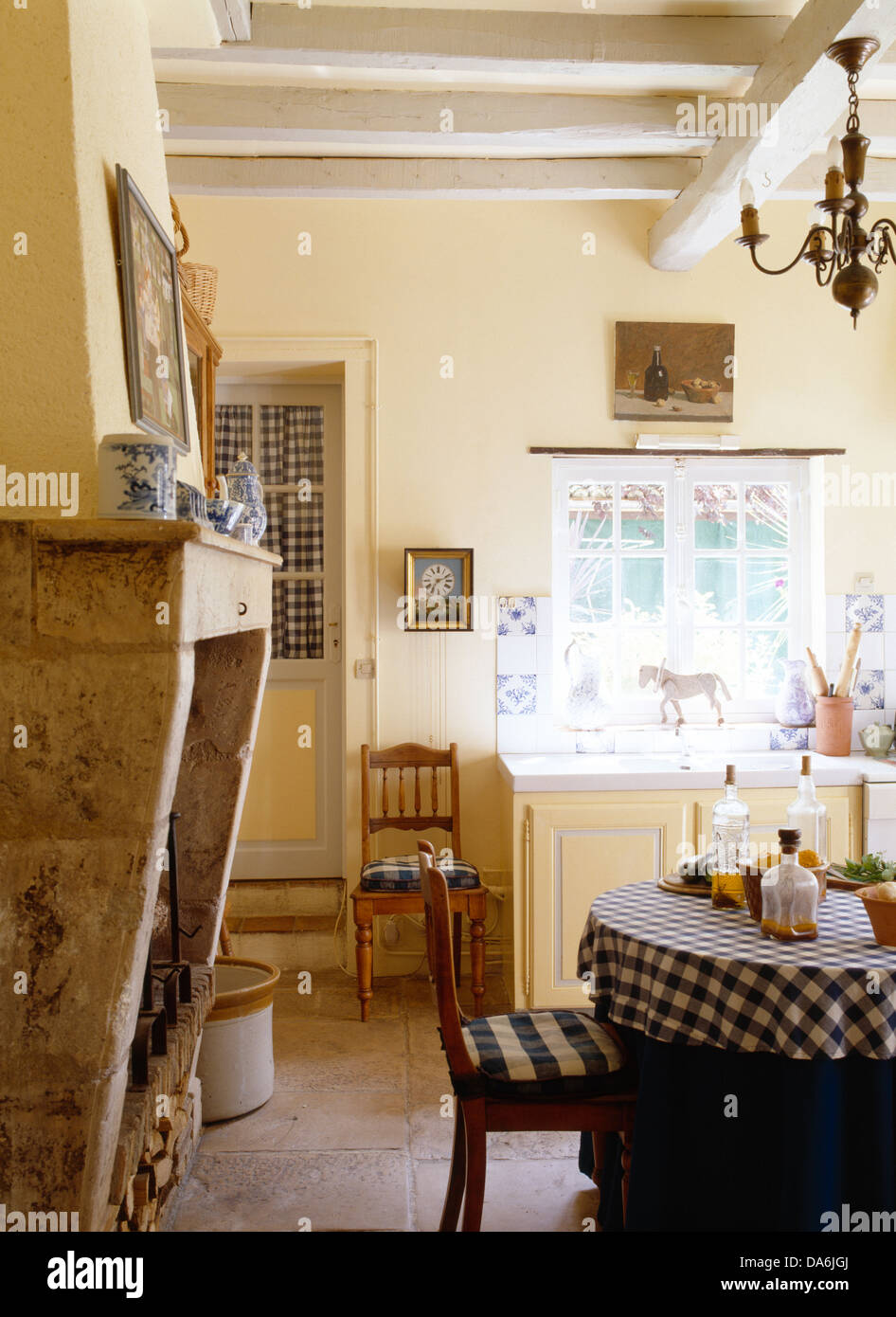 Stone Fireplace And White Painted Beams In Country Kitchen With