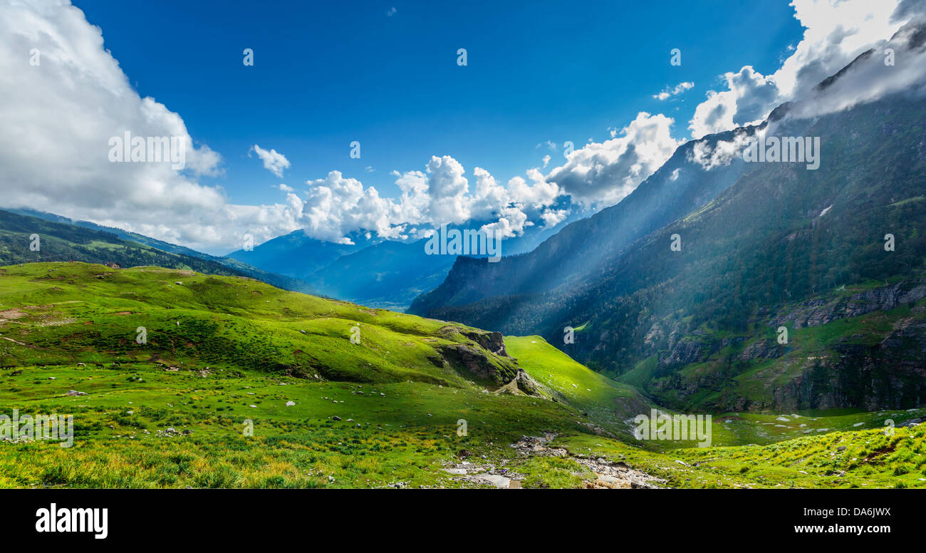 Peaceful alpine meadow mountain panorama in Himalayas with sun rays Stock Photo