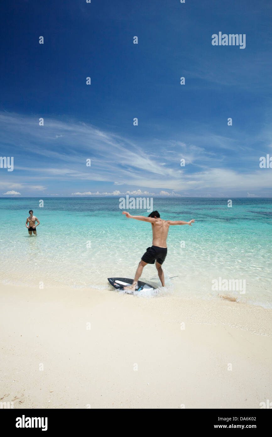 A man playing on a surfboard. Stock Photo