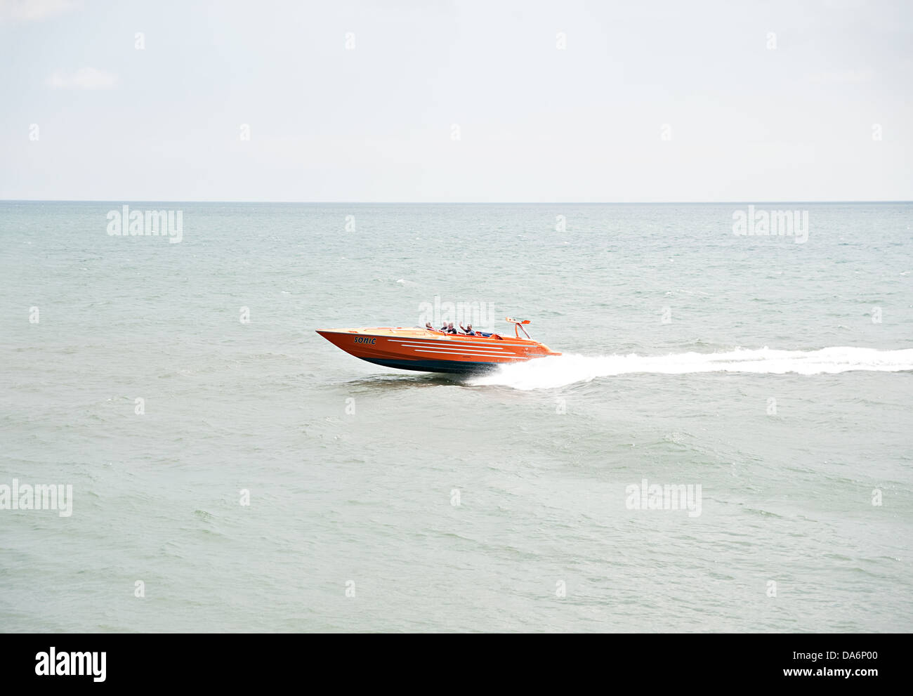 A speedboat with passengers on the high speed pass Stock Photo