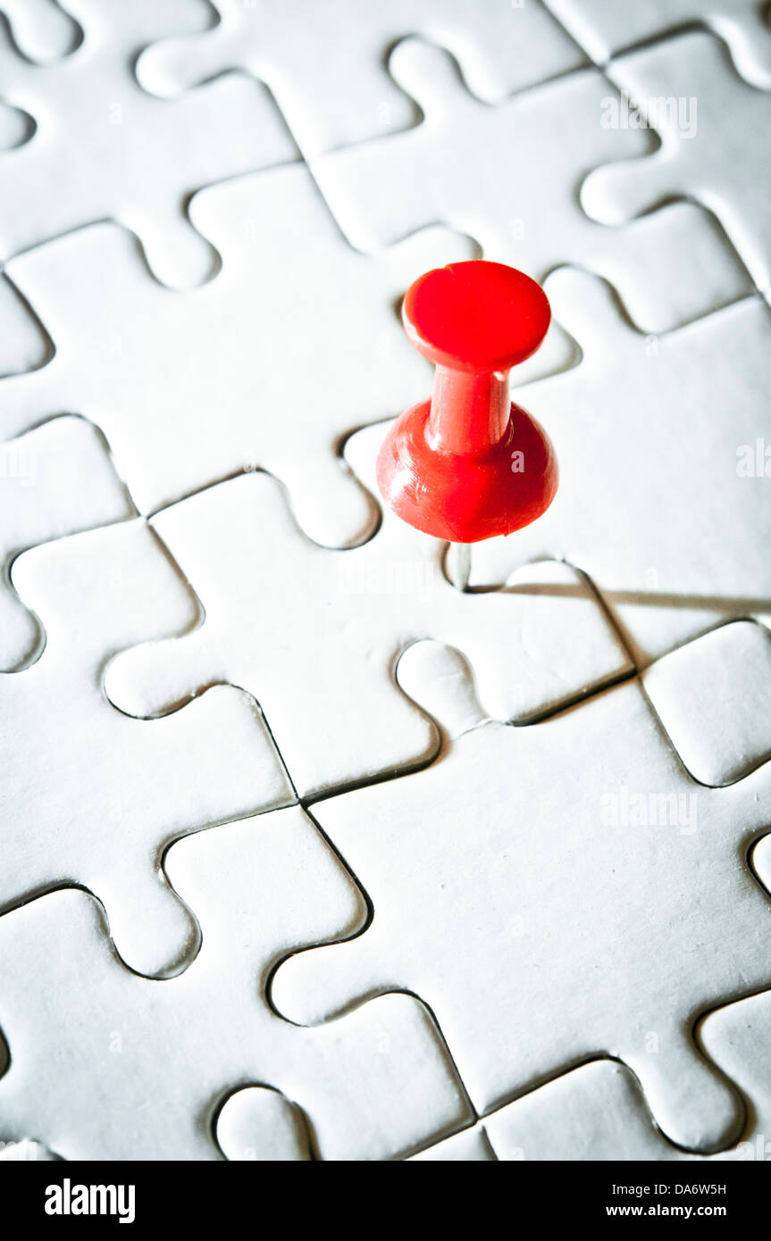 red pin on a blank jigsaw puzzle Stock Photo