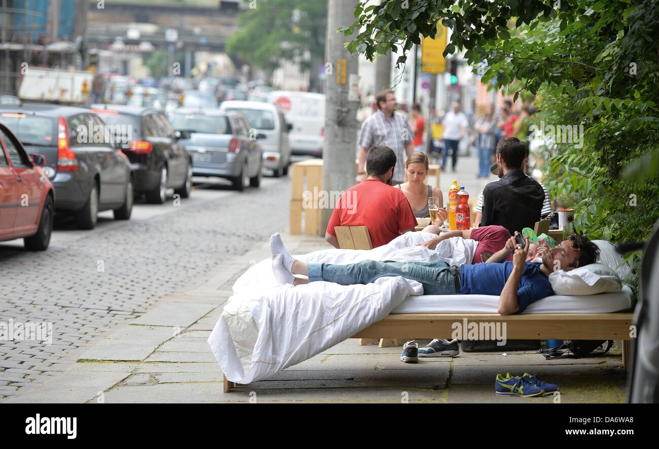 French artists Clement (R), Laurent (C, in bed) and Sebastien (3-R) camp on the street in Dresden, Germany, 05 July 2013. Two weeks ago the artists started the project '384 Stunden' ('384 hours') in Dresden. Since then they put up their mobile living room in different places in Dresden. Photo: BERND VON JUTRCZENKA Stock Photo