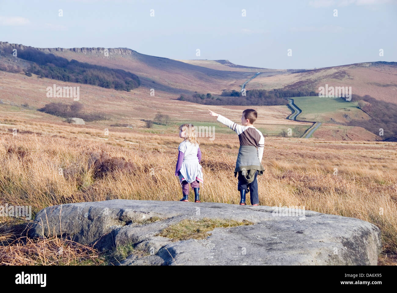 Young boy points out the way to the top of Stanage Edge to his little sister, Peak District, UK Stock Photo