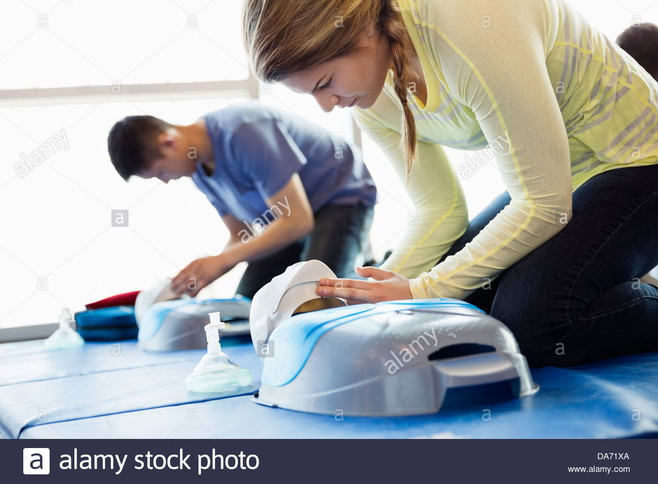 Woman practicing CPR on dummy in first aid class Stock Photo
