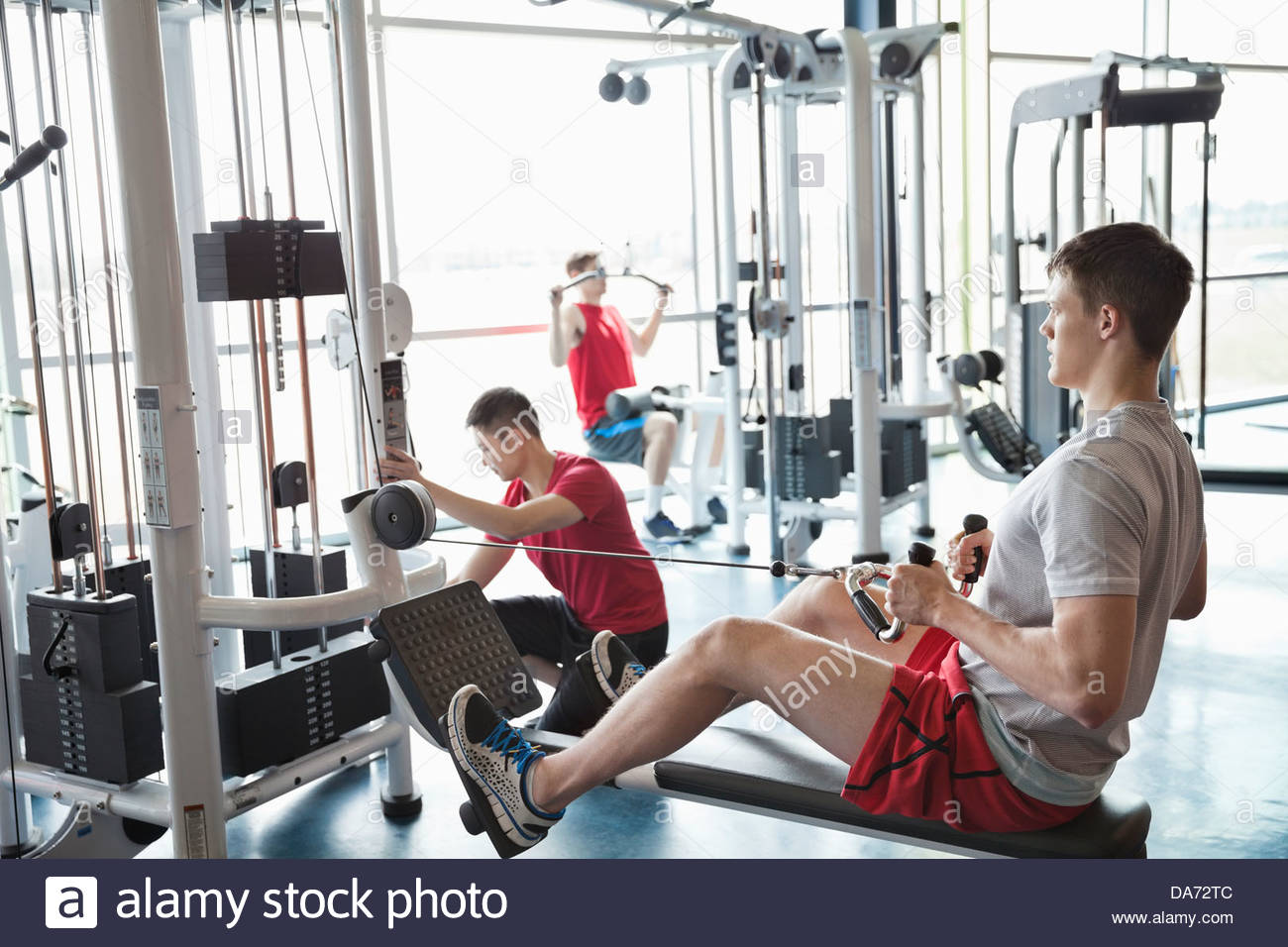 Men using weight machines in fitness center Stock Photo Alamy