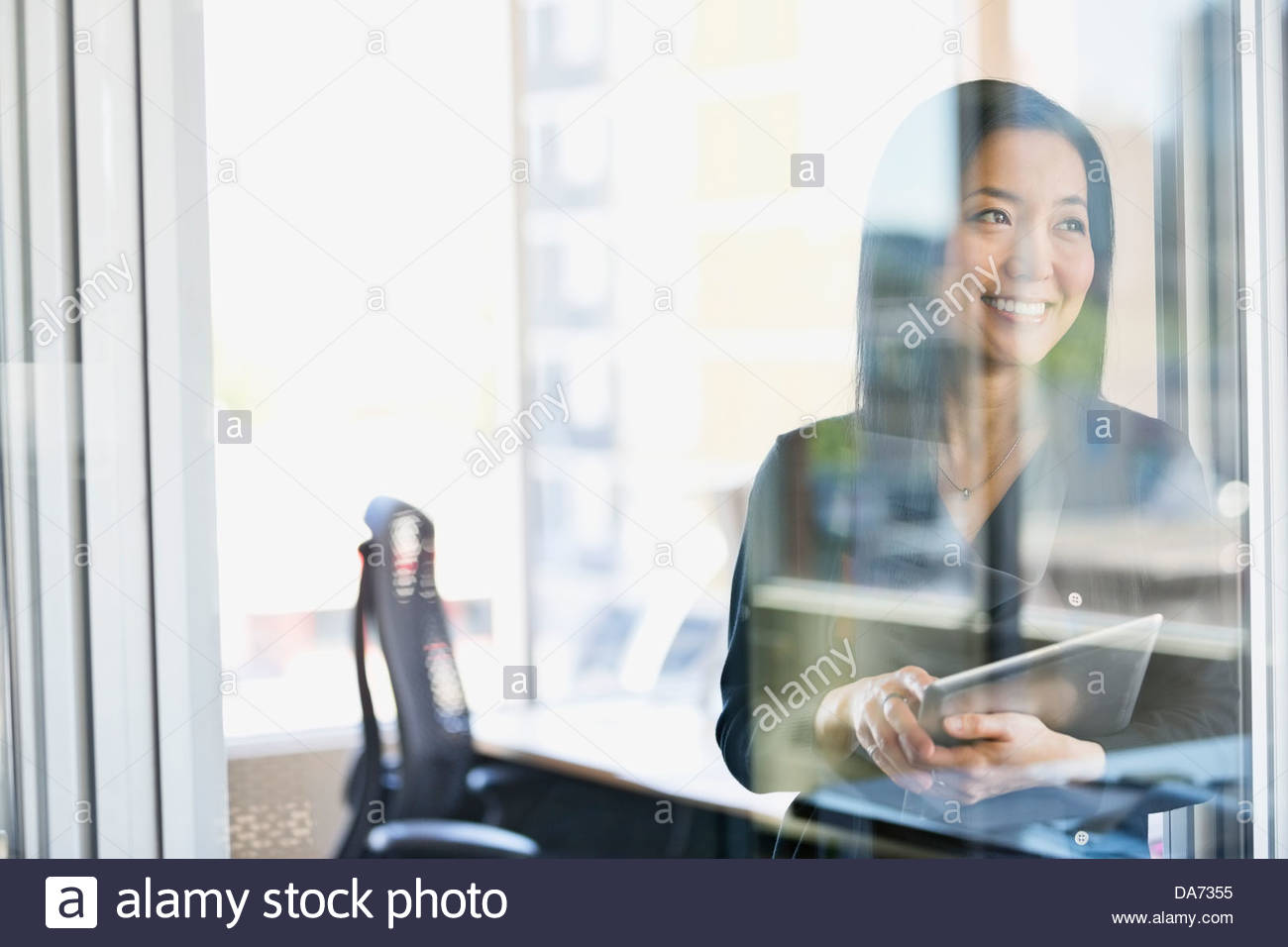 Smiling businesswoman with digital tablet in office Stock Photo