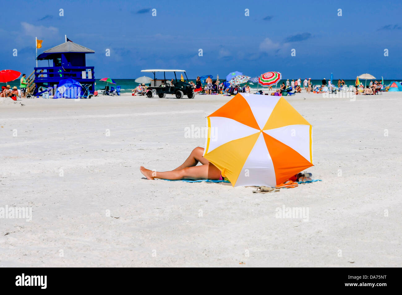 A woman sits beneath a beach Umbrella on Siesta Key Beach Florida Stock Photo Alamy