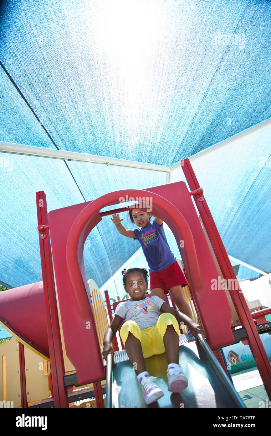 children playing on a playground slide hispanic asain caucasian Stock Photo