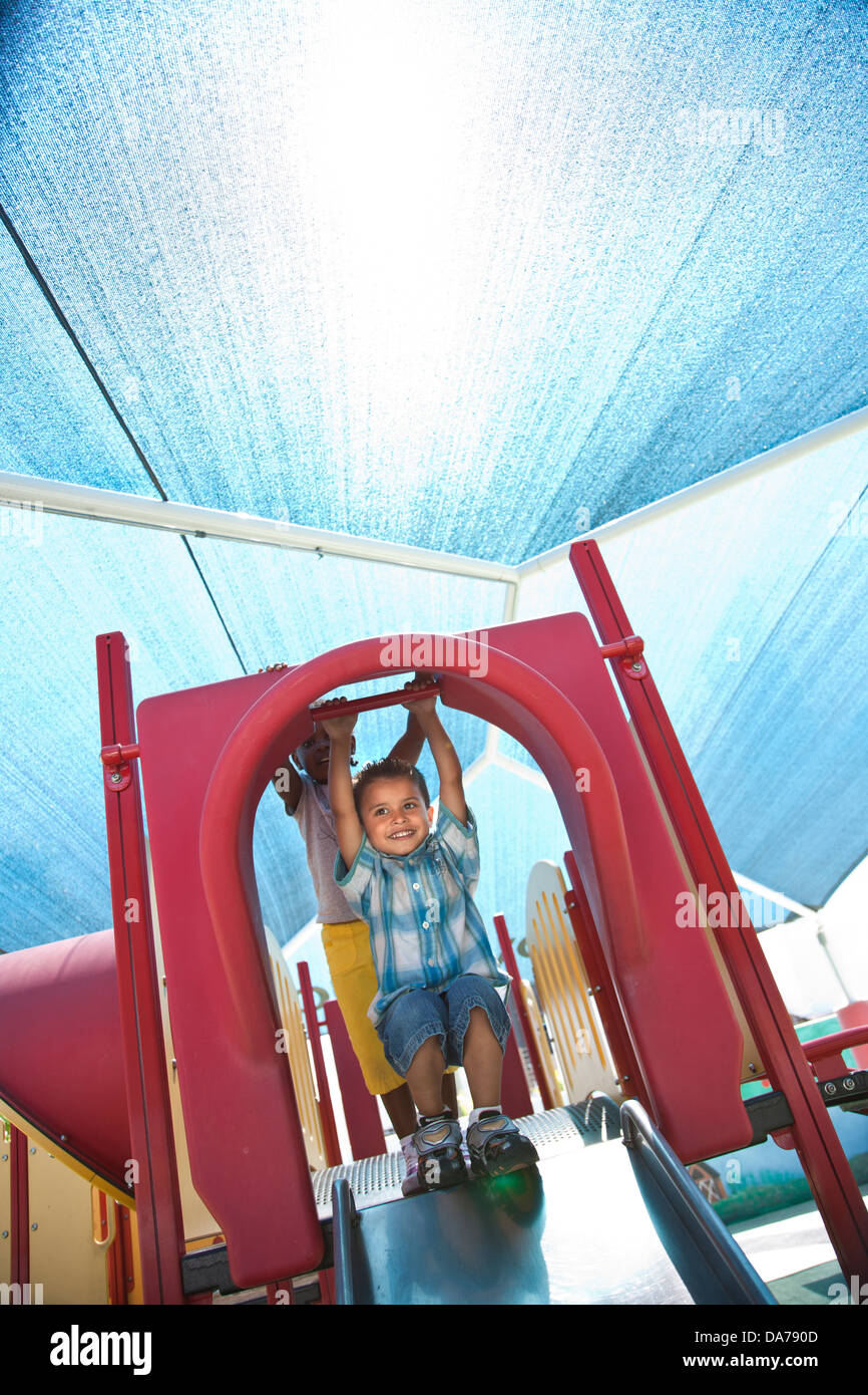 children playing on a playground slide hispanic asain caucasian Stock Photo