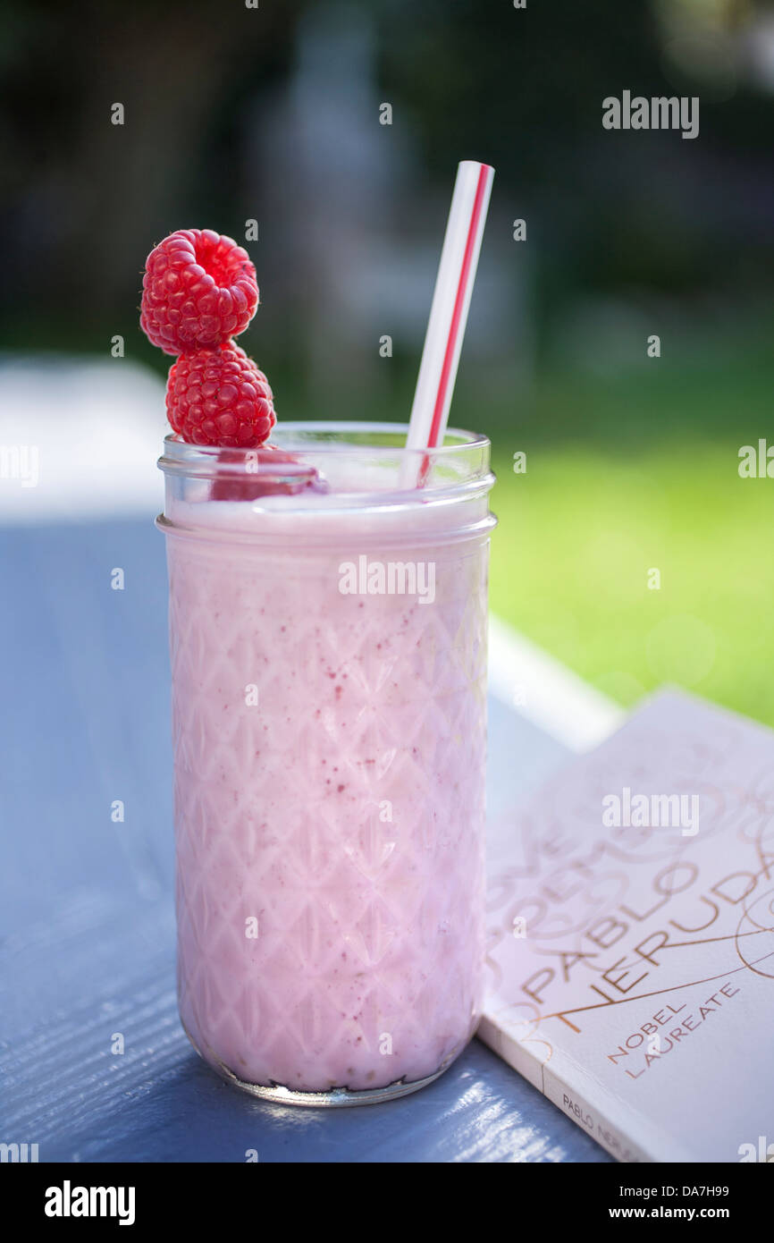 two raspberry smoothies outside on a sunny day Stock Photo