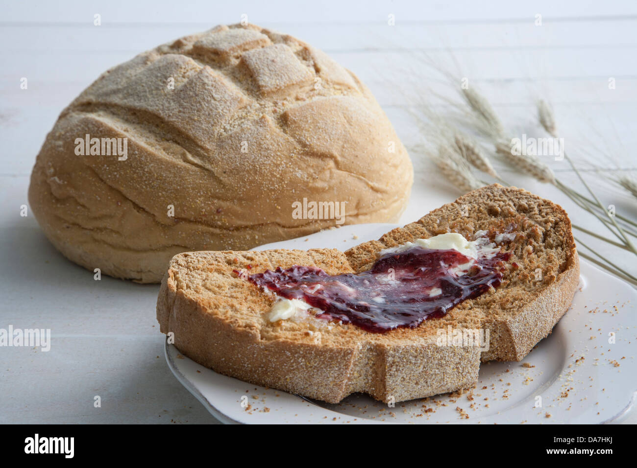 slice of homemade bread with melted butter and strawberry jam Stock Photo