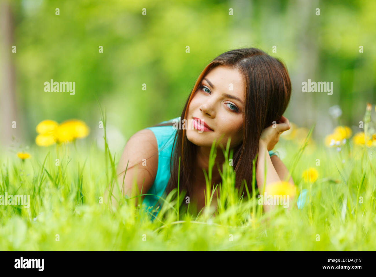 Beautiful young woman lying on grass with flowers Stock Photo - Alamy