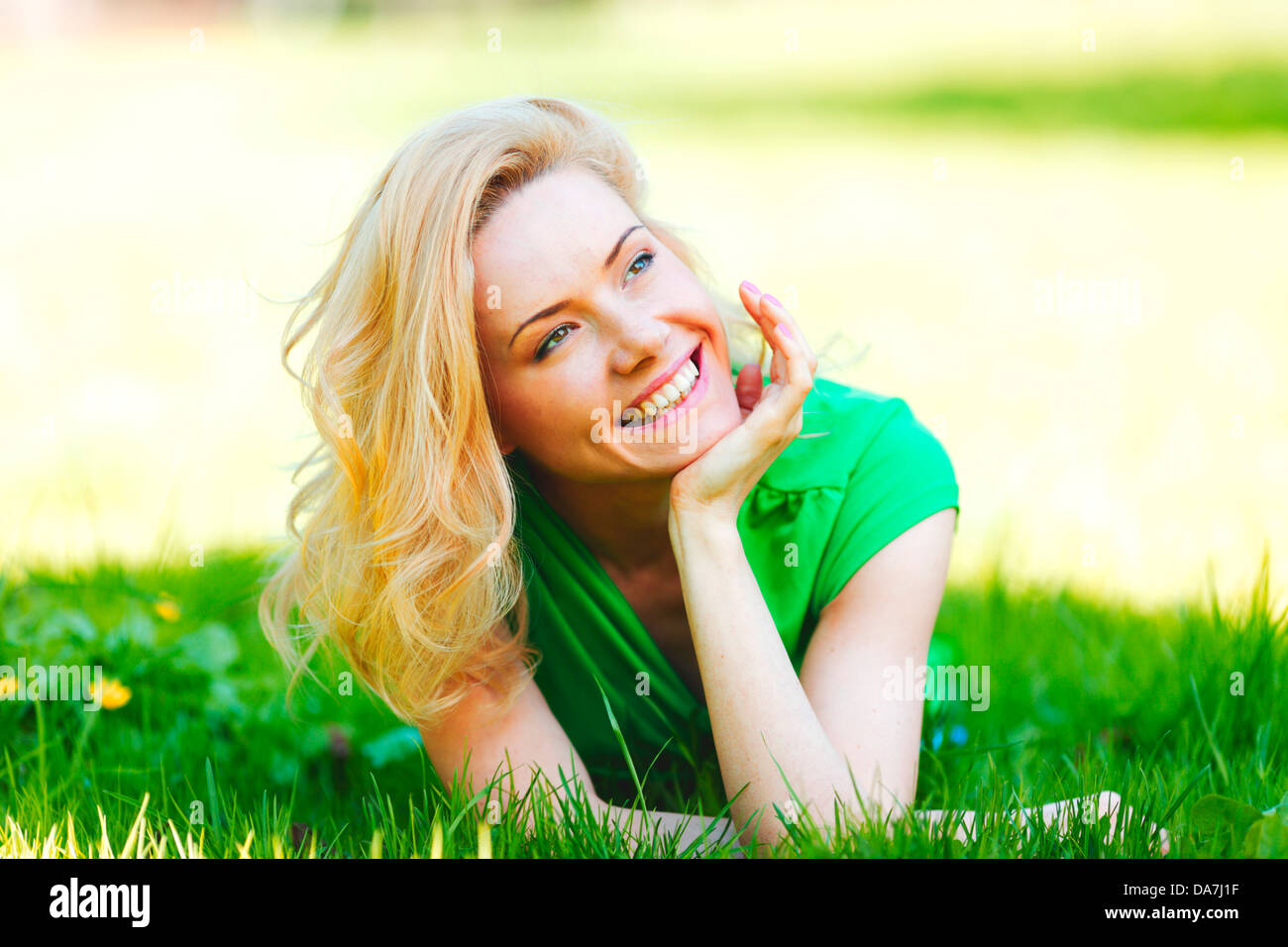 Happy young woman lying on grass Stock Photo - Alamy