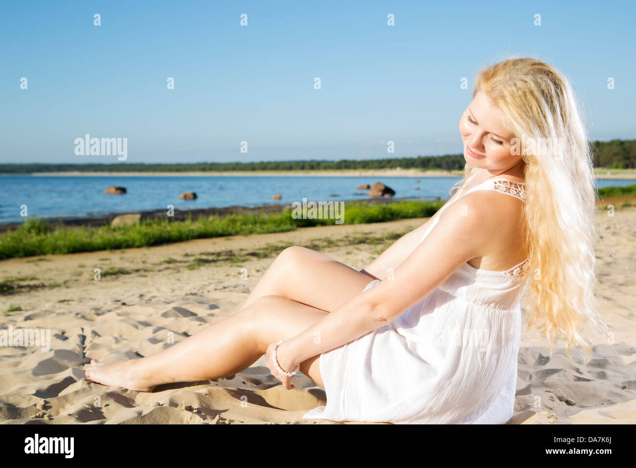 Woman in white dress indulgence on cool sand Stock Photo