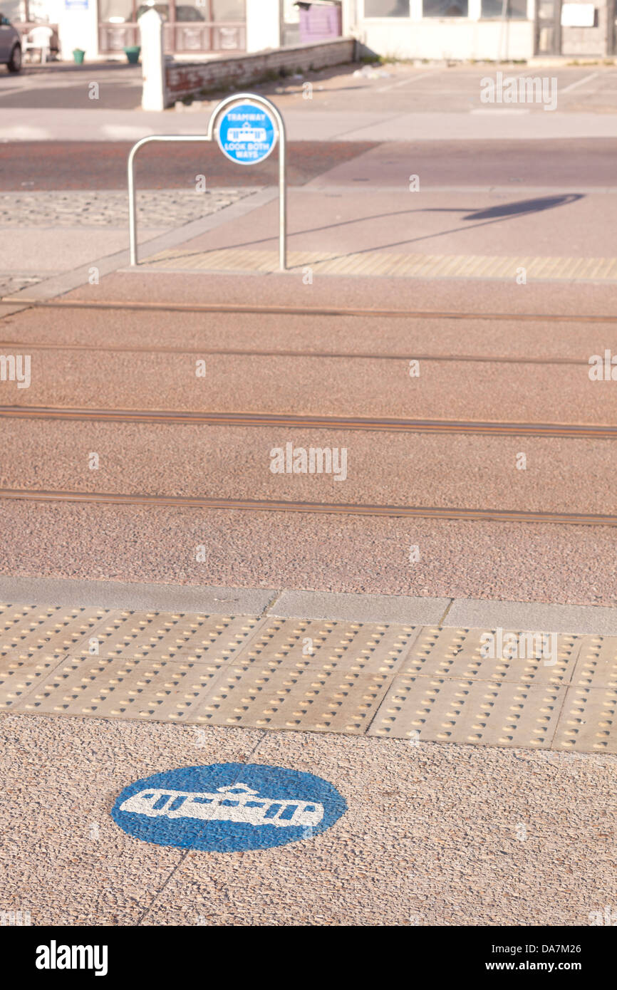 Pedestrian crossing point with markings for trams.  Focused on painted sign on ground. Stock Photo