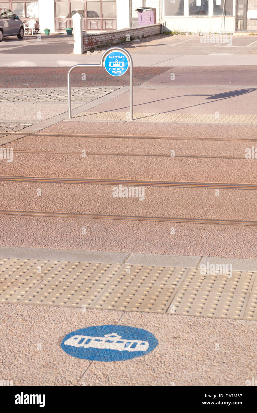 Pedestrian crossing point with markings for trams.  Focused on upright sign. Stock Photo