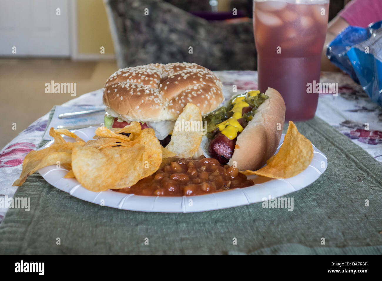 Barbeque hamburgers and hot dogs, cooked outdoors and eaten inside on paper plates. USA Stock Photo