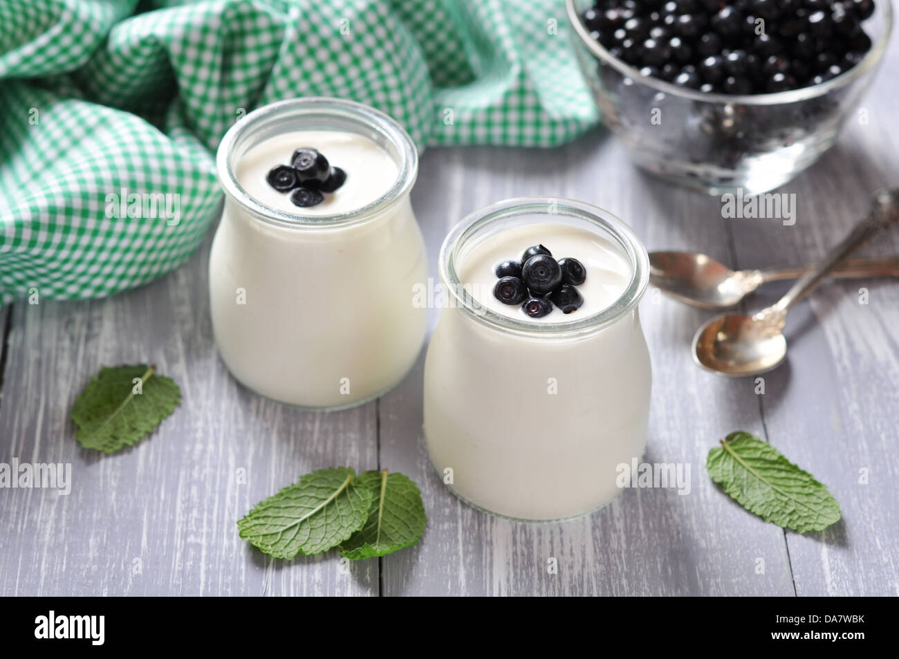 yogurt with ripe fresh blueberry in jars on wooden background Stock Photo