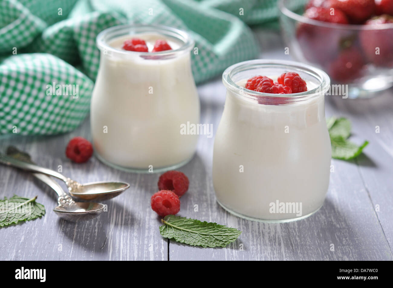yogurt with ripe fresh raspberry in jars on wooden background Stock Photo