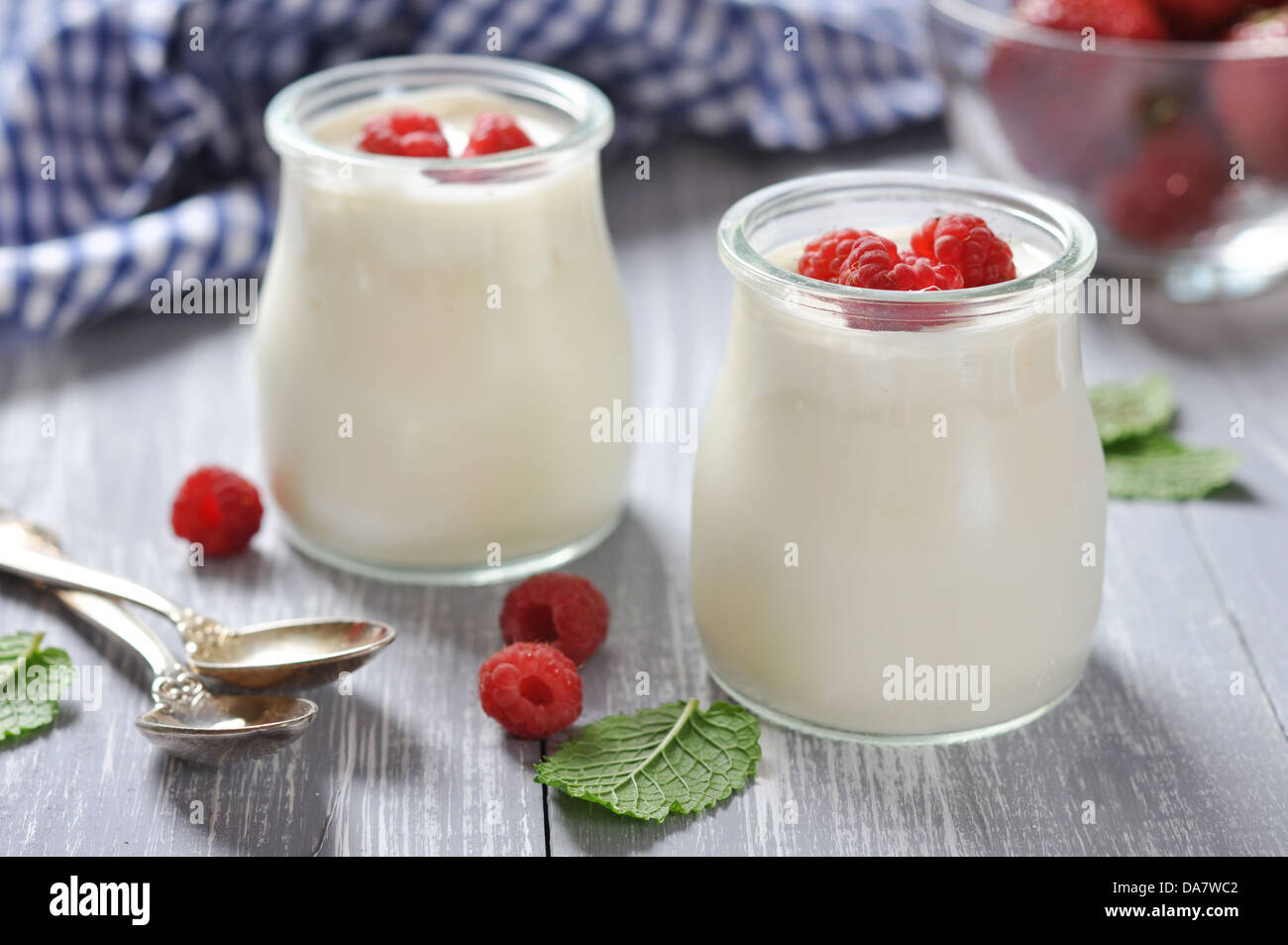 yogurt with ripe fresh raspberry in jars on wooden background Stock Photo
