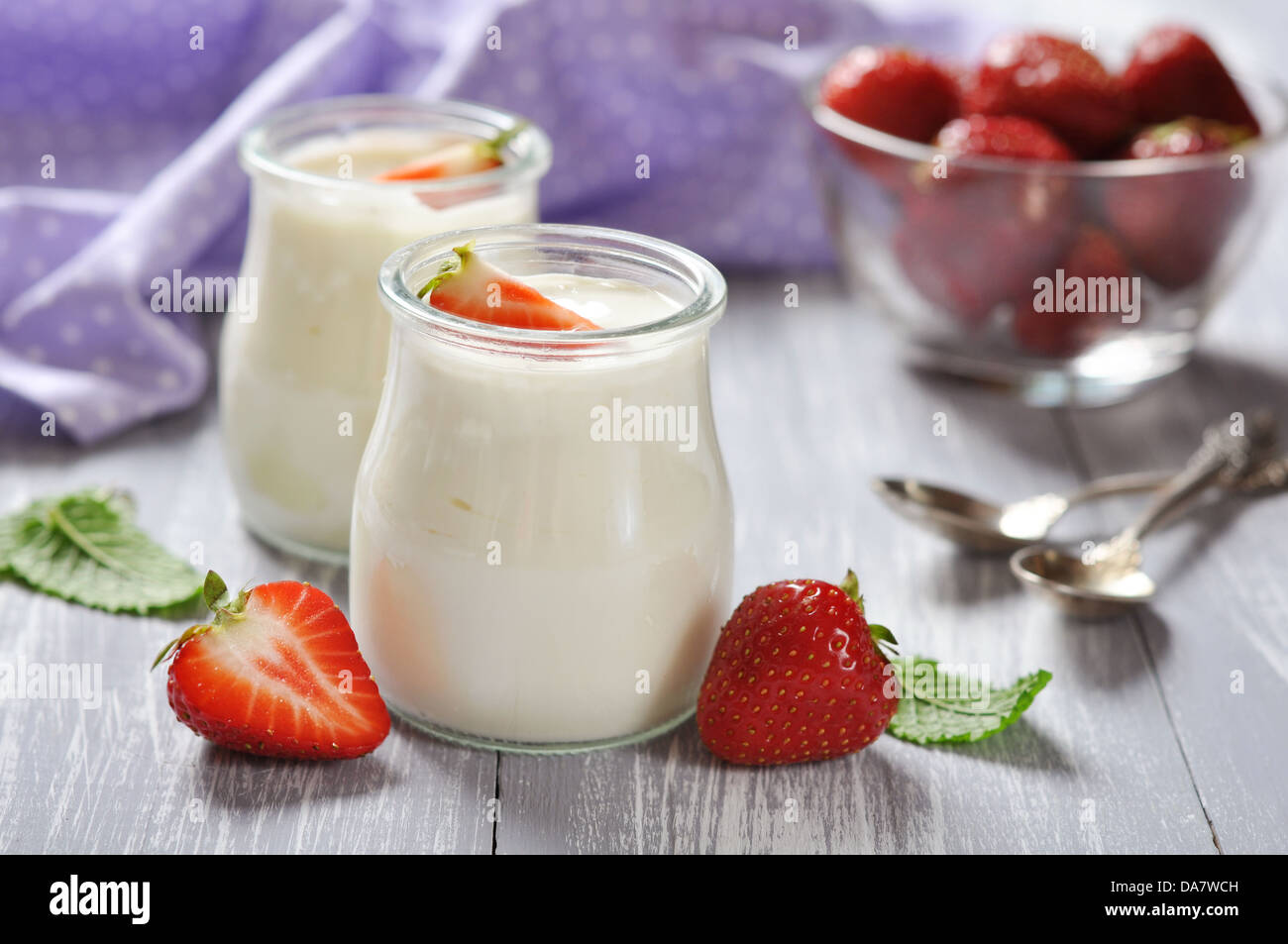 yogurt with ripe fresh strawberry in jars on wooden background Stock Photo