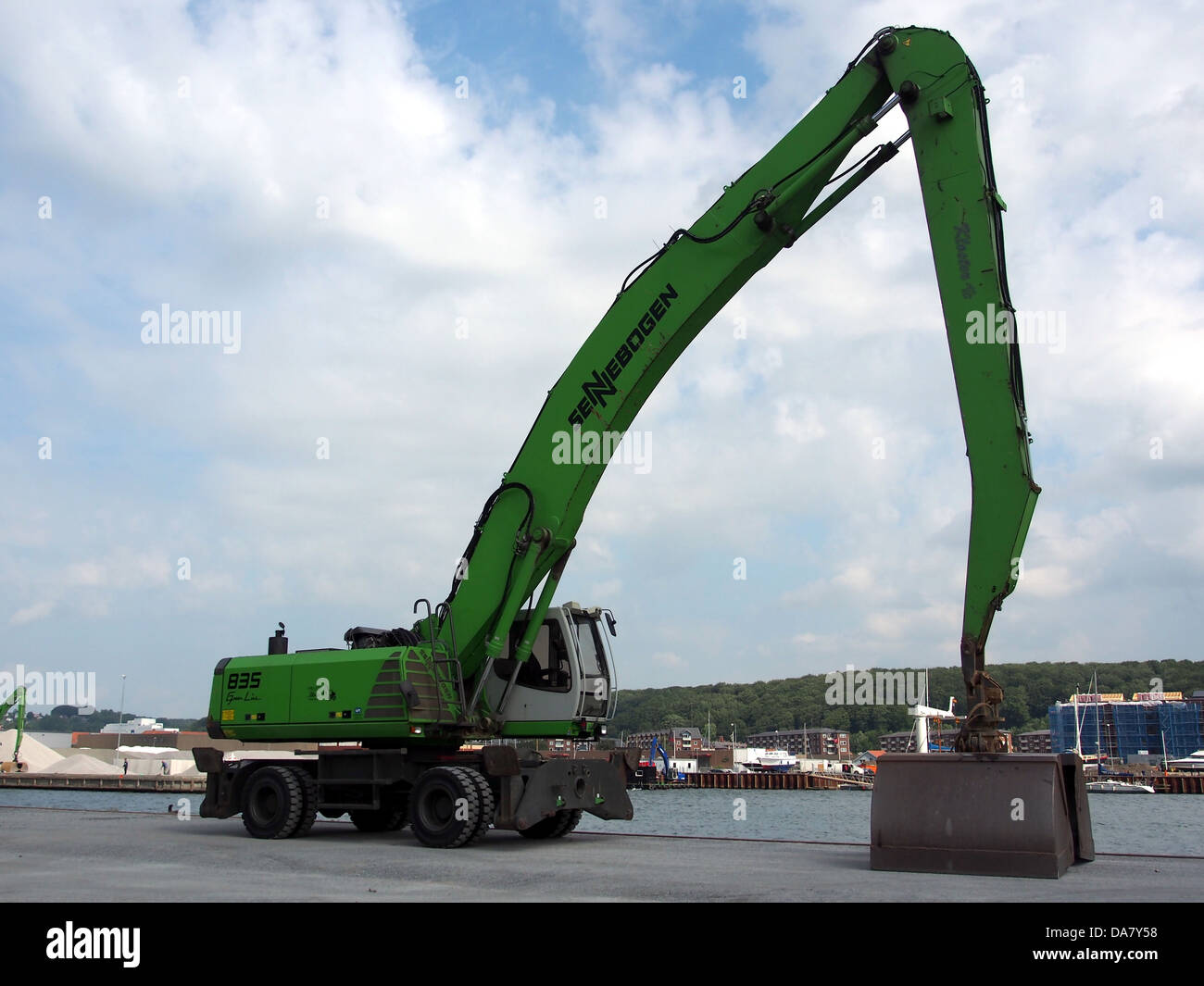 The Sennebogen 835 crane, located at the VEJLE harbor, is used for heavy lifting and cargo handling. It showcases advanced engineering and industrial design, providing essential support for port operations in Denmark. Stock Photo