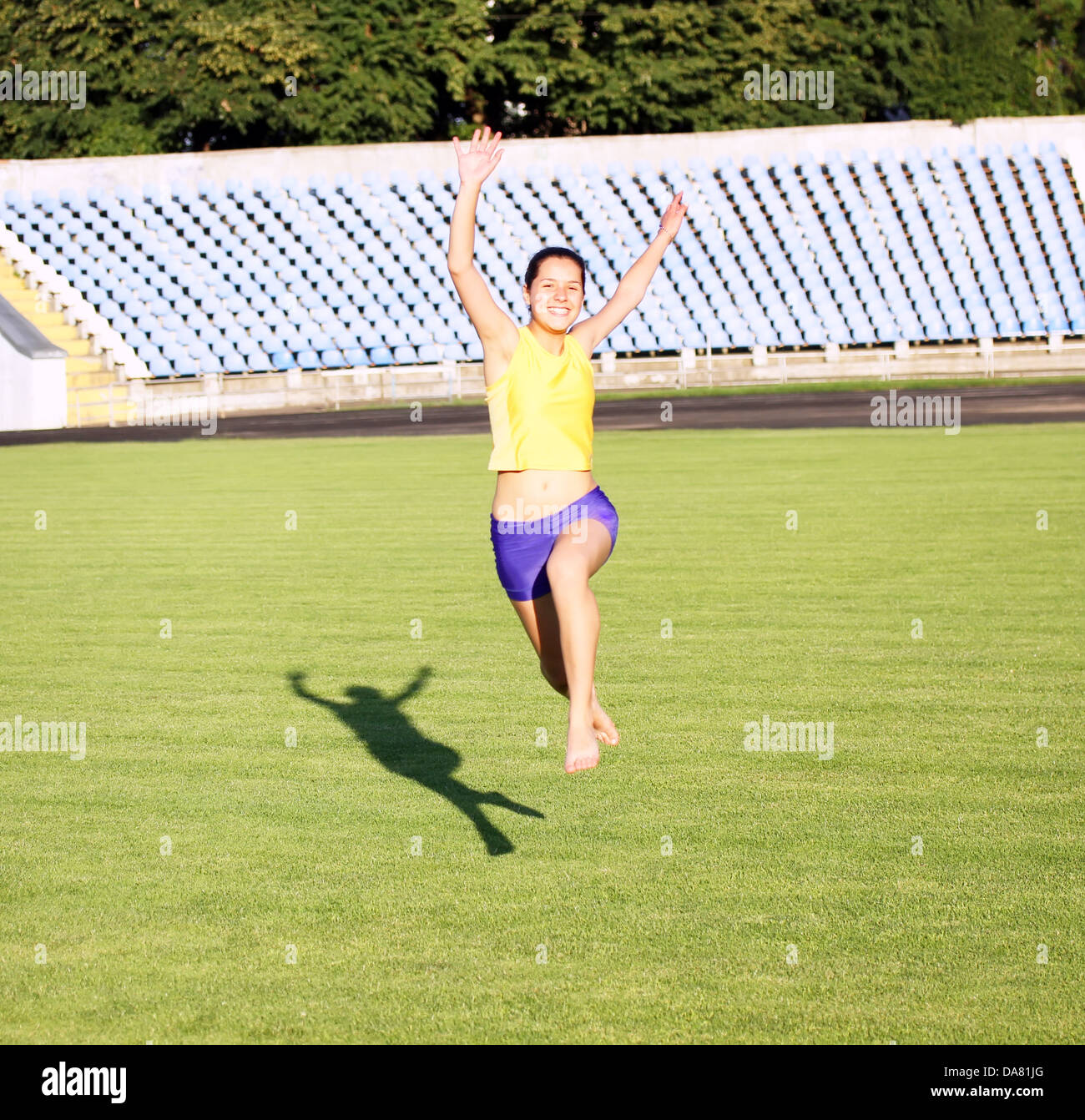 Beautiful teenage sport girl running on the grass go hires stock